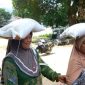 Warga usung satu sak beras di kepala.