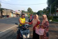 Ketua TP-PPK Kecamatan Suboh sekaligus Ketua Dharma Wanita Kecamatan Suboh, Yulia Rakhmawati, saat membagikan takjil gratis kepada pengendara yang melintas di depan kantor Kecamatan Suboh, Kabupaten Situbondo.(Foto: Hakim/Realita Publik) 