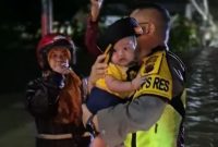 Terlihat, Kapolres Kebumen, AKBP Eka Baasith Syamsuri menggendong seorang balita yang berhasil diselamatkan dan dibawa dari lokasi terdampak banjir ke lokasi aman di Panjatan.(Foto: Wahyudin/realitapublik.id)