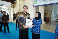 Bupati Indramayu, Lucky Hakim, secara simbolis menyerahkan SK kepada salah satu kepala sekolah.