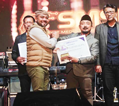 Penyerahan penghargaan dan plakat SMSI Award 2025 oleh Wakil Walikota Batu, Heli Susanto mewakili SMSI Malang Raya kepada Sam Tito.(Foto: Andy/realitapublik.id)