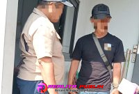 Oknum Satpam dengan wajah tegang menatap seorang wartawan di pos jaga SMKN 2 Kota Pasuruan, jalan Patiunus.