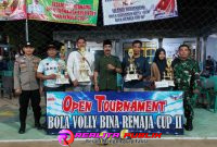 Perwakilan dari tim yang meraih juara memegang piala Open Turnamen Bola Voli Bina Remaja Cup II, bersama Suharno Kepala Tiyuh Tunas Asri serta Bhabinkamtibmas dan Babinsa Tiyuh Tunas Asri, Kecamatan Tulang Bawang Tengah, Kabupaten Tulang Bawang Barat. (Foto: Rodi Sandra/realitapublik.id) 
