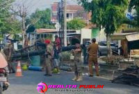 Tim Sat Pol PP sedang menurunkan baliho/bener tanpa izin di wilayah Indramayu kota.